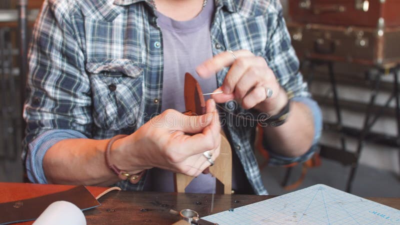 Hombre en artículo de cuero de costura comprobado de la camisa