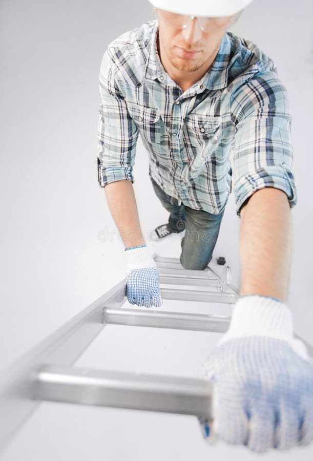 Hombre en casco y guantes que suben la escalera fotografía de archivo libre de regalías Hombre en casco y guantes que suben la escalera fotografía de archivo libre de regalías