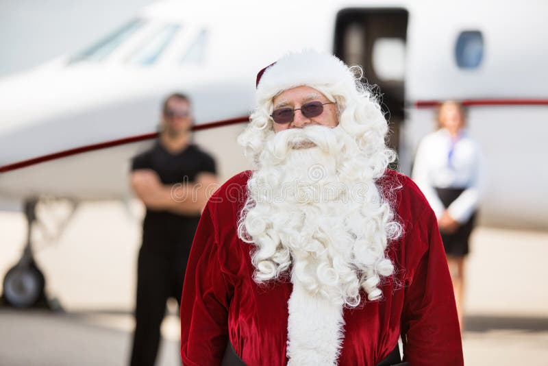 Hombre en el jet de Santa Costume Standing Against Private foto de archivo Hombre en el jet de Santa Costume Standing Against Private foto de archivo