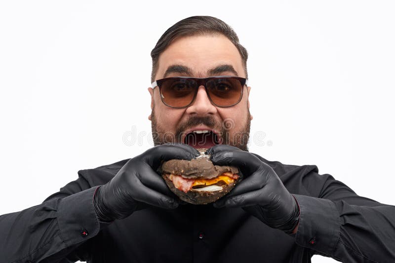 Hombre En Gafas Que Muerde La Hamburguesa Imagen de archivo - de comida, comer: 142785131