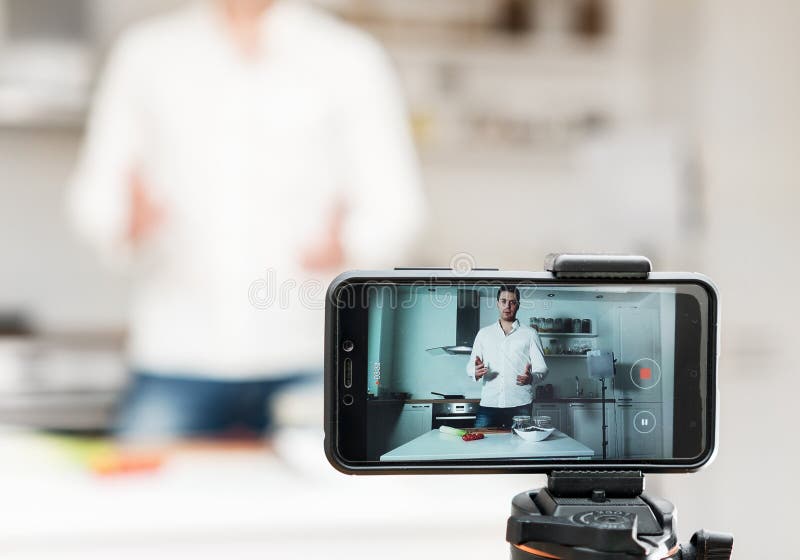 Man on the kitchen filming video. Vlogging concept. Man on the kitchen filming video. Vlogging concept