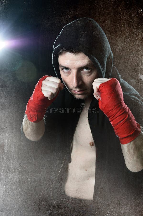 Hombre en puente de la sudadera con capucha del boxeo con la capilla en la cabeza con las muñecas envueltas de las manos listas p foto de archivo Hombre en puente de la sudadera con capucha del boxeo con la capilla en la cabeza con las muñecas envueltas de las manos listas p foto de archivo