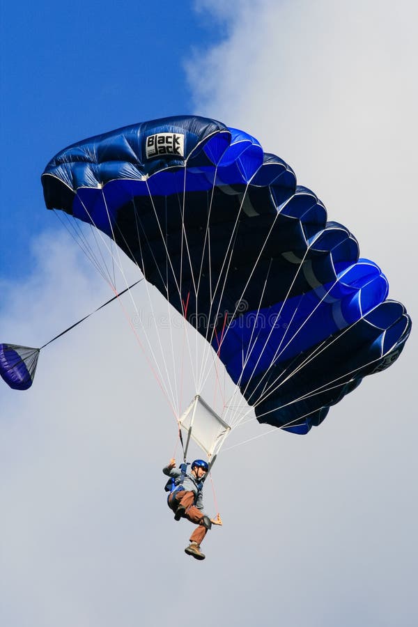 Hombre en un vuelo azul del paracaídas imágenes de archivo libres de regalías Hombre en un vuelo azul del paracaídas imágenes de archivo libres de regalías