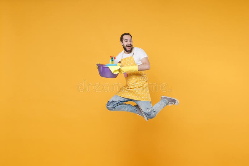 Hombre excitado ama de casa en guantes de manzana sostener botellas detergentes lavadoras lavadoras haciendo tareas domésticas ais imagen de archivo