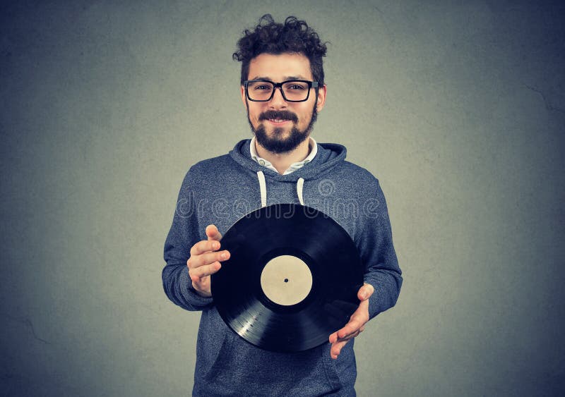 Hombre feliz del inconformista con el disco del vinilo imágenes de archivo libres de regalías Hombre feliz del inconformista con el disco del vinilo imágenes de archivo libres de regalías