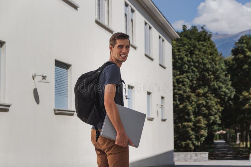 Hombre feliz joven con la mochila que camina a la escuela después de vacaciones de verano fotos de archivo Hombre feliz joven con la mochila que camina a la escuela después de vacaciones de verano fotos de archivo