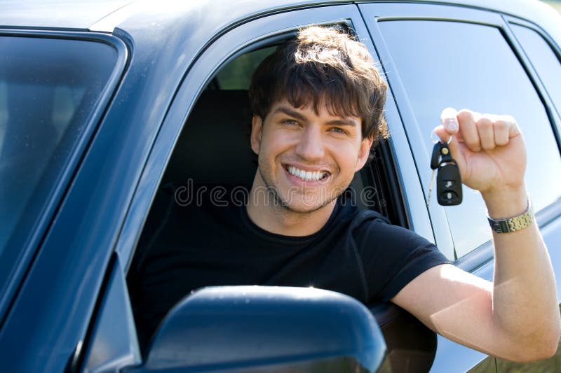 Hombre feliz que muestra claves en coche imágenes de archivo libres de regalías Hombre feliz que muestra claves en coche imágenes de archivo libres de regalías