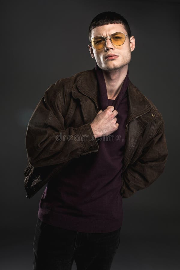 Portrait of sure young male keeping collar of sweater by hand. He isolated on black background. Certainty concept. Portrait of sure young male keeping collar of sweater by hand. He isolated on black background. Certainty concept