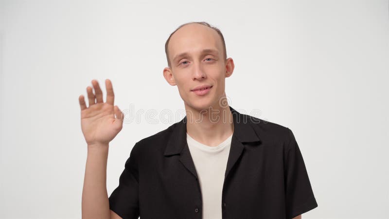 Hombre guapo con problemas de salud del pelo pérdida de cabello y calvicie diciendo hola a la cámara usando camisa negra aislada e