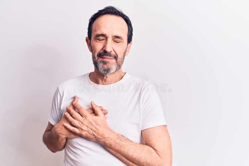Hombre guapo de mediana edad con camisa casual de pie sobre fondo blanco aislado sonriendo con las manos en el pecho ojos cerrados foto de archivo libre de regalías