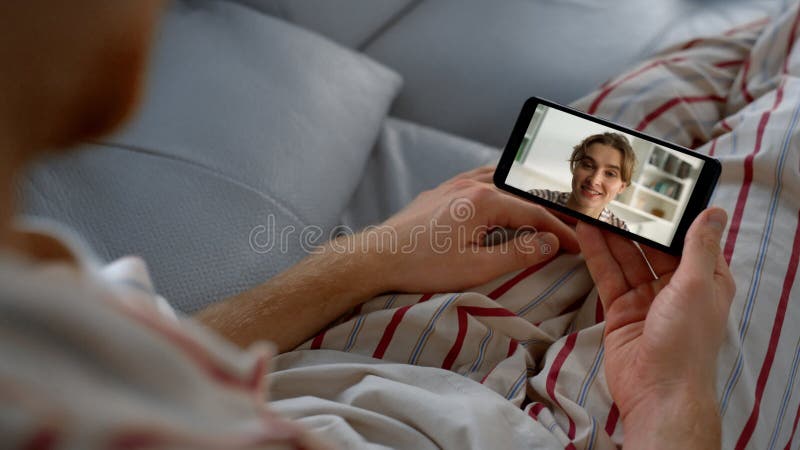 Hombre hablando de videochat por smartphone con novia cloup. mujer sonriente saludando almacen de metraje de vídeo