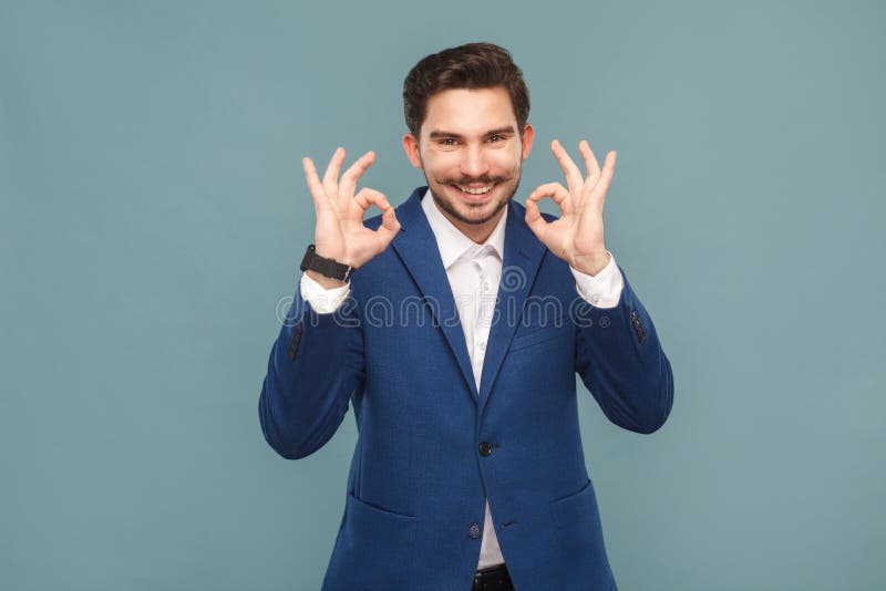 Hombre hermoso con el bigote que muestra la muestra aceptable en la cámara fotografía de archivo Hombre hermoso con el bigote que muestra la muestra aceptable en la cámara fotografía de archivo
