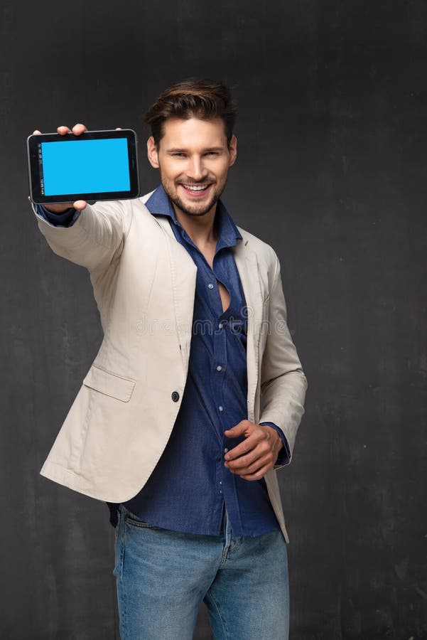 Hombre hermoso feliz con la tableta fotografía de archivo Hombre hermoso feliz con la tableta fotografía de archivo