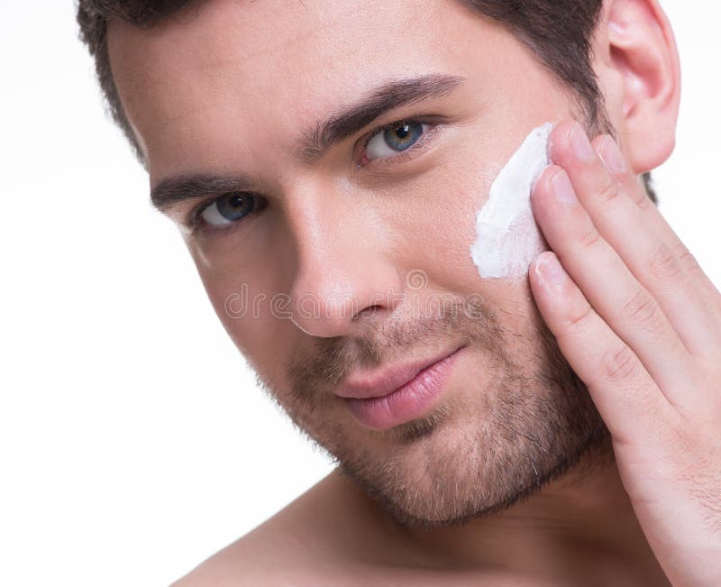 Hombre hermoso joven que aplica la crema. fotografía de archivo libre de regalías