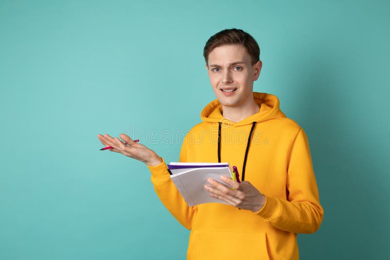 Hombre hermoso joven ropa casual manejar, el llevar con el cuaderno y pluma en las manos que piensan en solucionar un difícil imagen de archivo Hombre hermoso joven ropa casual manejar, el llevar con el cuaderno y pluma en las manos que piensan en solucionar un difícil imagen de archivo
