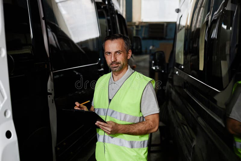 Hombre inspeccionando coches en la fábrica imágenes de archivo libres de regalías