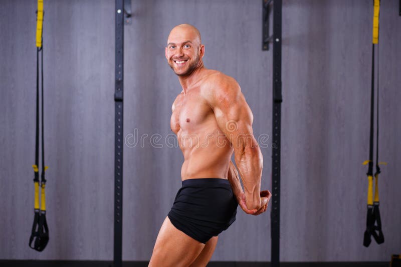 Hombre intrépido rasgado fuerte que demuestra los músculos grandes en gimnasio Deporte, imagen de archivo libre de regalías Hombre intrépido rasgado fuerte que demuestra los músculos grandes en gimnasio Deporte, imagen de archivo libre de regalías