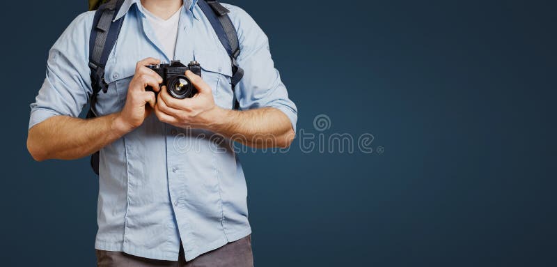 Hombre irreconocible del Blogger del viajero del hombre con la cámara de la mochila y de la película en fondo azul Caminar concep fotografía de archivo libre de regalías Hombre irreconocible del Blogger del viajero del hombre con la cámara de la mochila y de la película en fondo azul Caminar concep fotografía de archivo libre de regalías