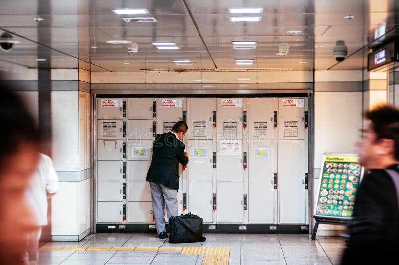 Hombre japonés usando el armario en la estación de tren de Nagoya fotos de archivo libres de regalías Hombre japonés usando el armario en la estación de tren de Nagoya fotos de archivo libres de regalías