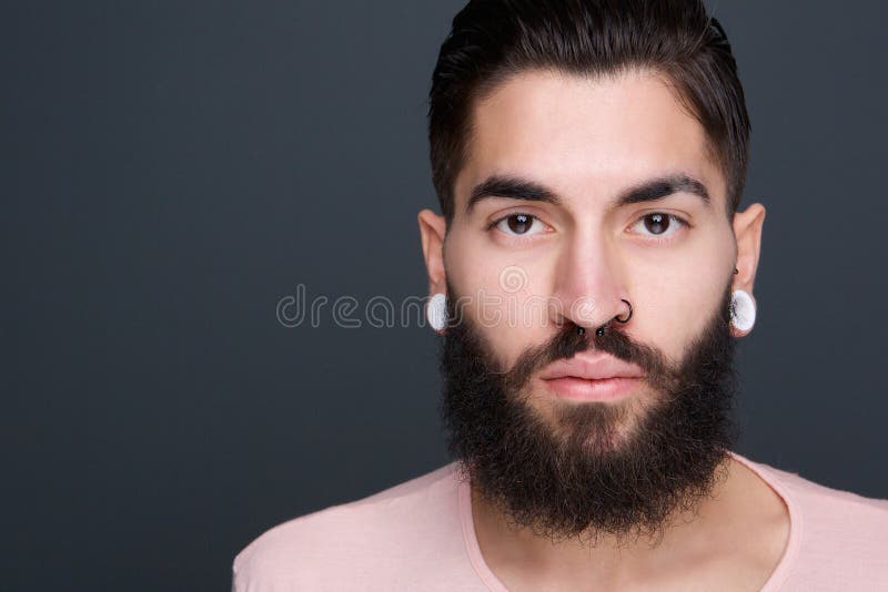 Hombre joven con la barba y perforaciones