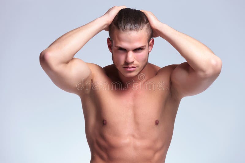 Hombre joven con las tetas al aire con las manos en pelo imágenes de archivo libres de regalías Hombre joven con las tetas al aire con las manos en pelo imágenes de archivo libres de regalías