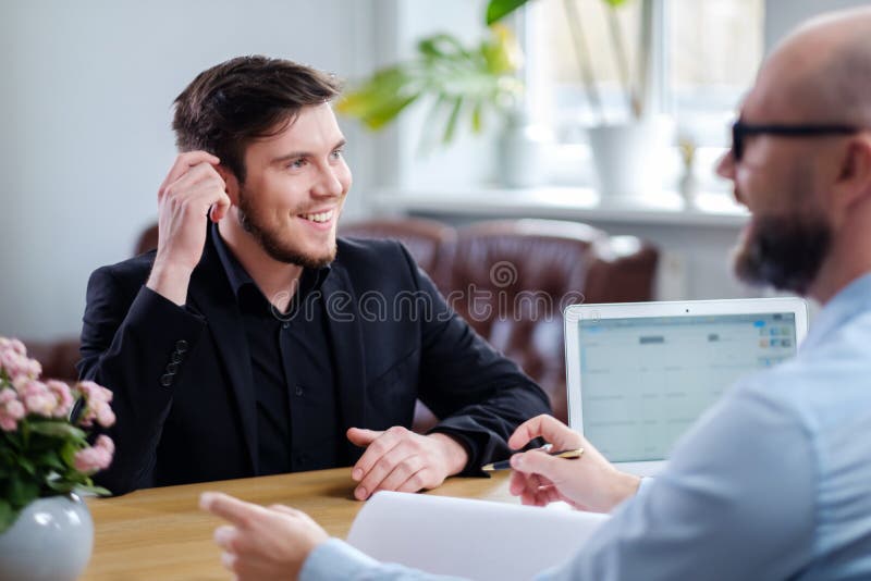 Hombre joven confiado que asiste a entrevista de trabajo foto de archivo libre de regalías Hombre joven confiado que asiste a entrevista de trabajo foto de archivo libre de regalías