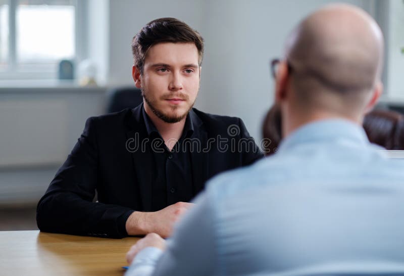 Hombre joven confiado que asiste a entrevista de trabajo foto de archivo Hombre joven confiado que asiste a entrevista de trabajo foto de archivo