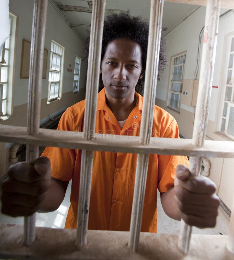 Hombre joven del afroamericano detrás de barras imágenes de archivo libres de regalías Hombre joven del afroamericano detrás de barras imágenes de archivo libres de regalías