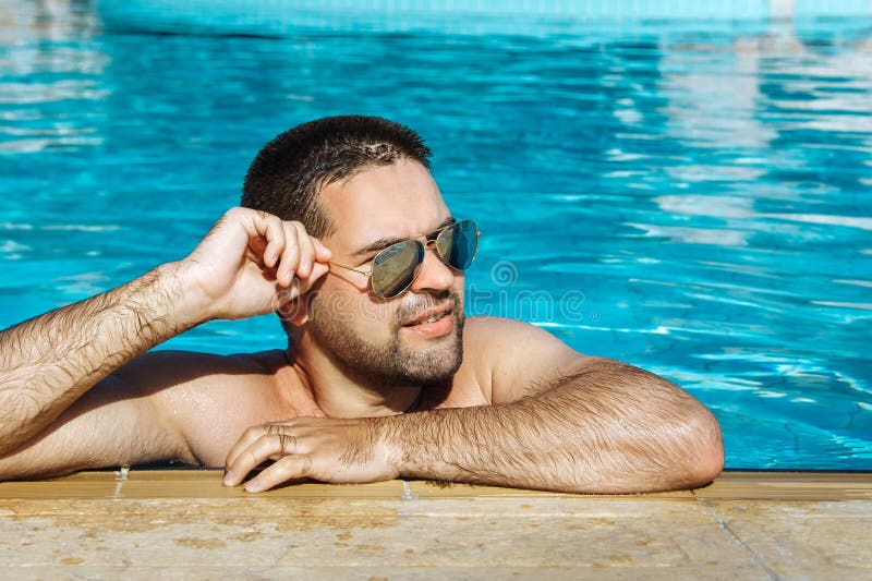 Hombre Joven En La Reclinación De Las Gafas De Sol Relajada En El Borde De  La Piscina Imagen de archivo - Imagen de gente, piscina: 86580165