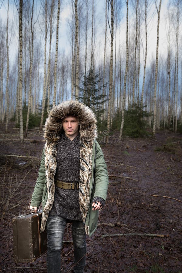 Hombre Joven En Abrigo Esquimal Verde Invierno En Un Bosque Con Una Maleta Imagen de archivo - Imagen de oscuro: 107135005