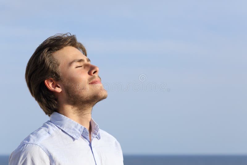 Hombre joven feliz que respira profundamente imagen de archivo Hombre joven feliz que respira profundamente imagen de archivo