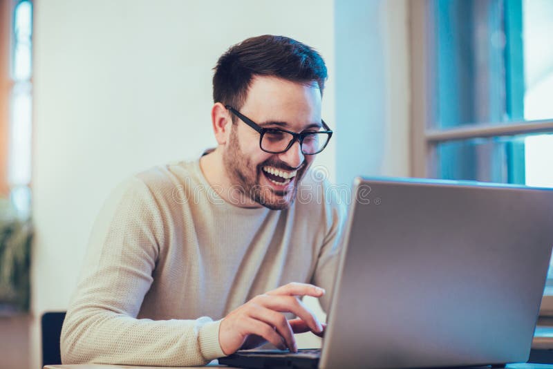 Hombre joven feliz, vidrios que llevan y sonrisa foto de archivo Hombre joven feliz, vidrios que llevan y sonrisa foto de archivo