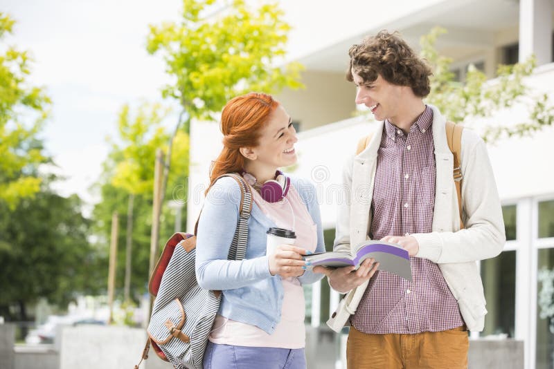 Hombre joven feliz y mujer que estudian junto en el campus de la universidad imagen de archivo libre de regalías Hombre joven feliz y mujer que estudian junto en el campus de la universidad imagen de archivo libre de regalías