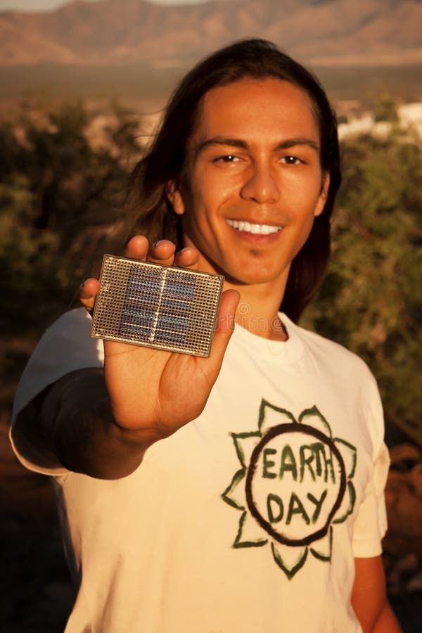 Hombre joven hermoso con el pequeño panel solar foto de archivo libre de regalías Hombre joven hermoso con el pequeño panel solar foto de archivo libre de regalías