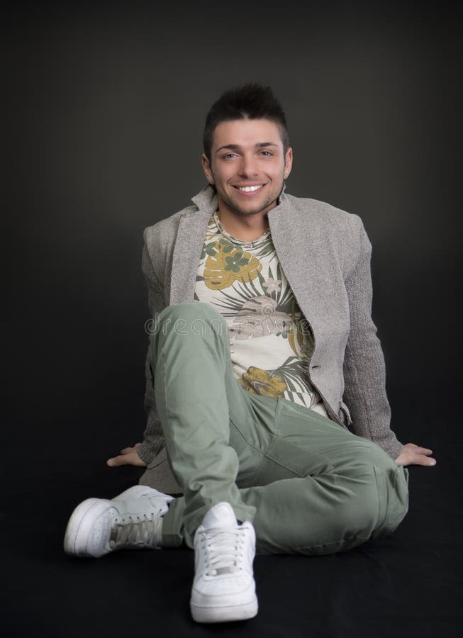 Hombre joven hermoso con la sentada de la chaqueta de las lanas imagen de archivo libre de regalías Hombre joven hermoso con la sentada de la chaqueta de las lanas imagen de archivo libre de regalías
