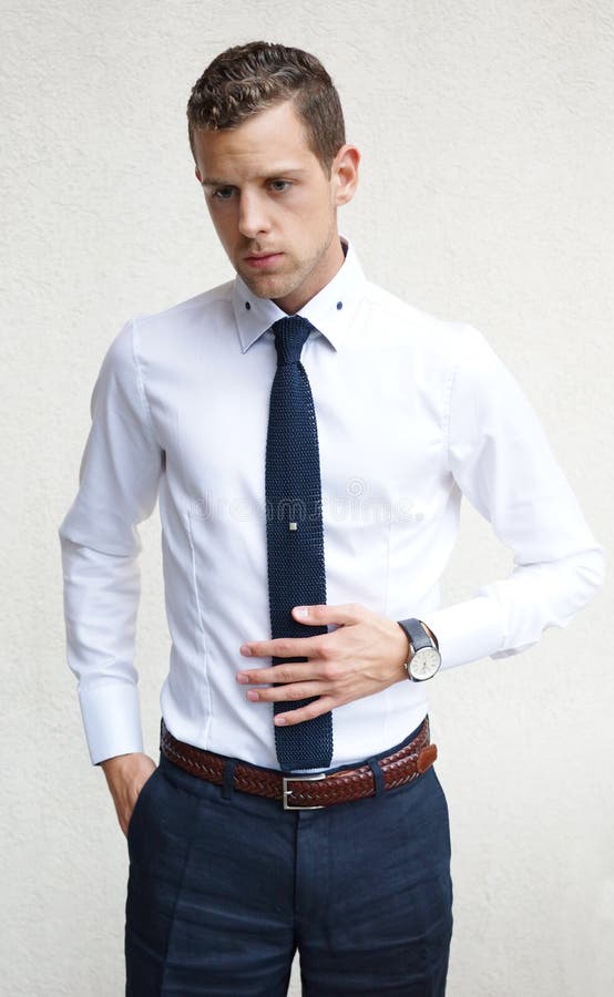 Hombre Joven Hermoso Que Lleva Lazo Azul De La Camisa Blanca Foto - Imagen de asentado, pantalones: