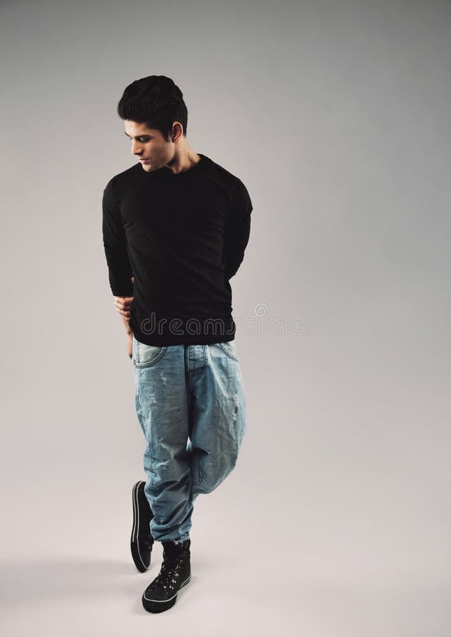 Hombre joven hispánico en la presentación casual en fondo gris imagenes de archivo