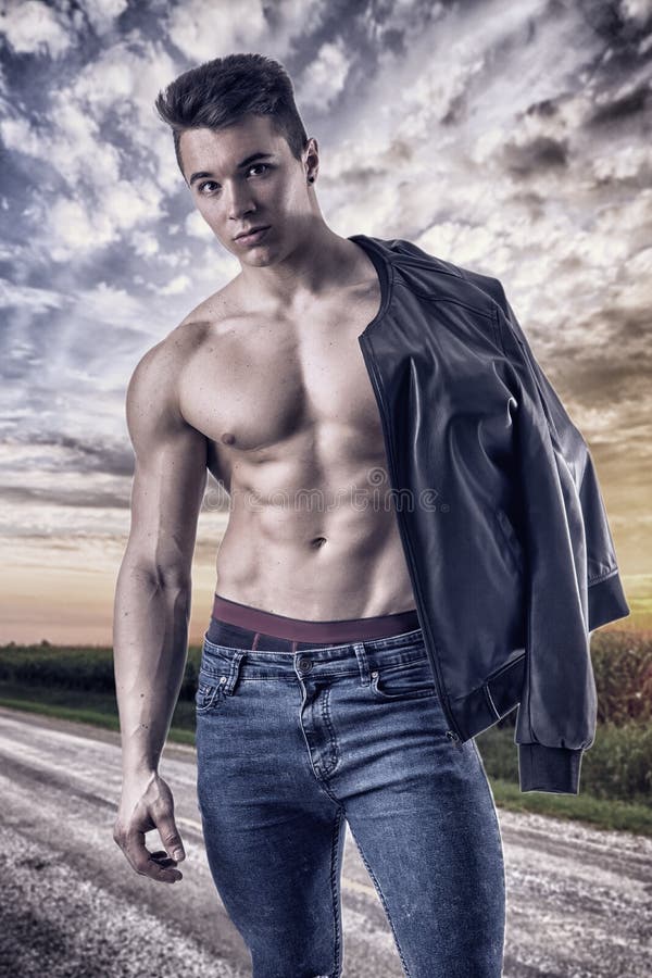 Hombre joven muscular descamisado que camina en el camino rural fotos de archivo Hombre joven muscular descamisado que camina en el camino rural fotos de archivo