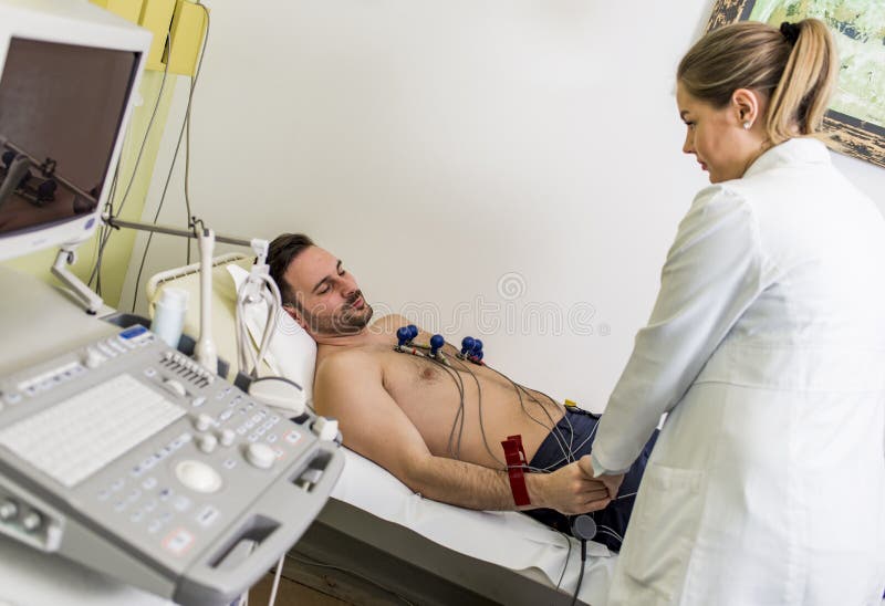Hombre joven que hace ECG en hospital fotos de archivo Hombre joven que hace ECG en hospital fotos de archivo