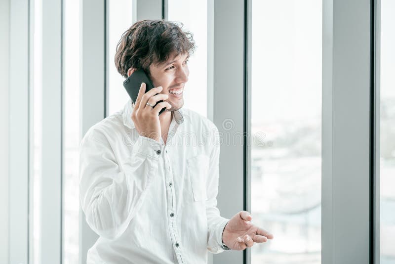 Hombre joven que lleva la ropa casual que habla en el teléfono móvil fotos de archivo Hombre joven que lleva la ropa casual que habla en el teléfono móvil fotos de archivo