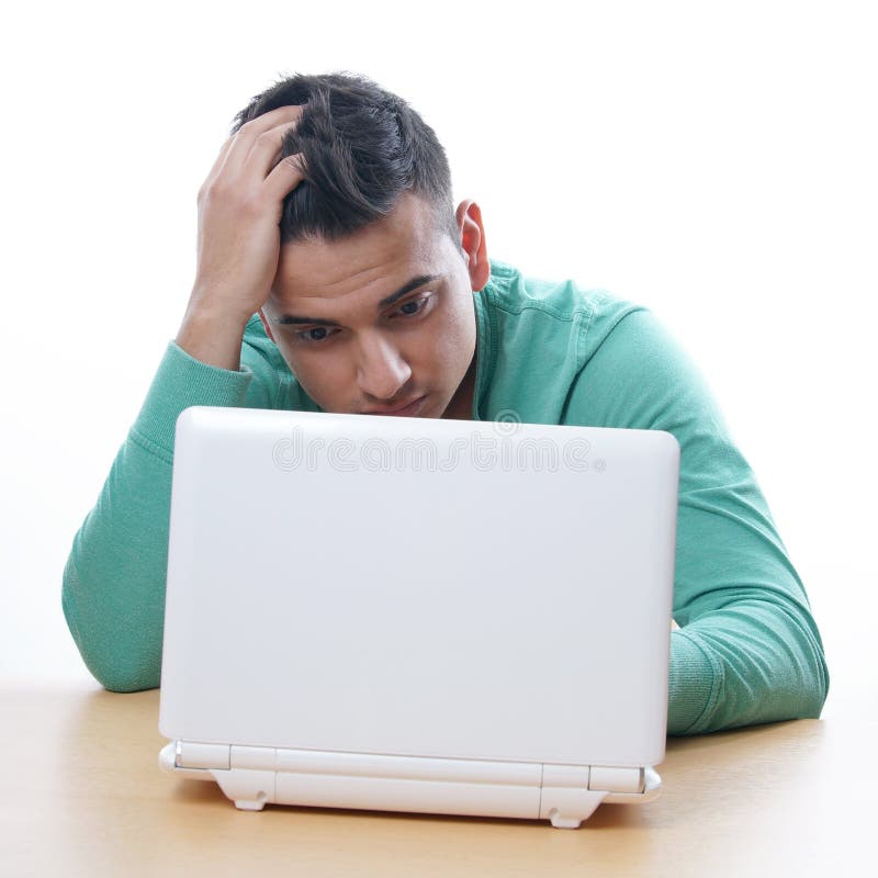 Hombre joven que mira fijamente el netbook foto de archivo