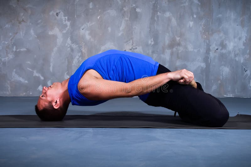 Hombre joven que realiza un Matsyasana foto de archivo libre de regalías Hombre joven que realiza un Matsyasana foto de archivo libre de regalías