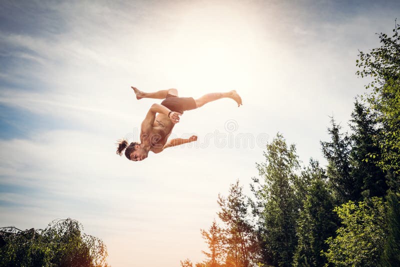 Hombre joven que salta arriba en el cielo imagen de archivo libre de regalías Hombre joven que salta arriba en el cielo imagen de archivo libre de regalías