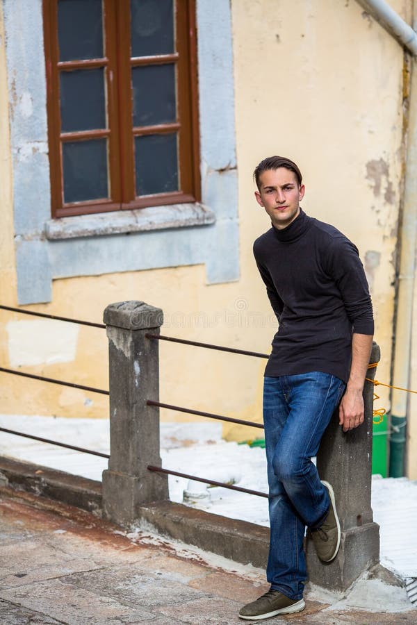 Hombre joven que se coloca en el callejón en la ciudad vieja Paseo pausado fotografía de archivo libre de regalías Hombre joven que se coloca en el callejón en la ciudad vieja Paseo pausado fotografía de archivo libre de regalías