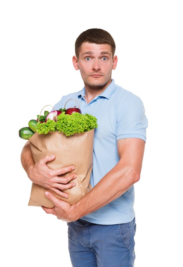 Hombre joven que sostiene el panier lleno de verduras aisladas en el fondo blanco fotografía de archivo Hombre joven que sostiene el panier lleno de verduras aisladas en el fondo blanco fotografía de archivo