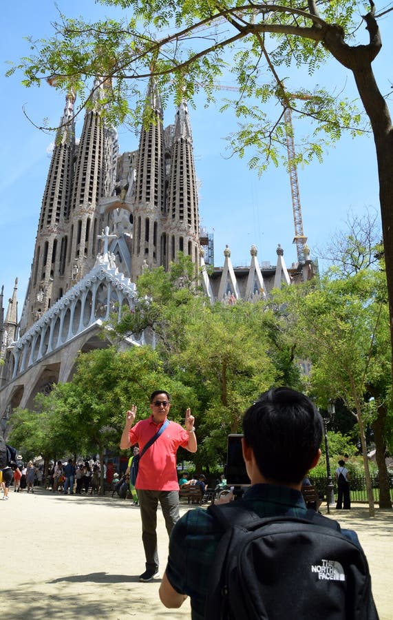 Hombre joven que toma la foto de la persona madura con el La Sagrada Familia en el fondo fotografía de archivo libre de regalías Hombre joven que toma la foto de la persona madura con el La Sagrada Familia en el fondo fotografía de archivo libre de regalías