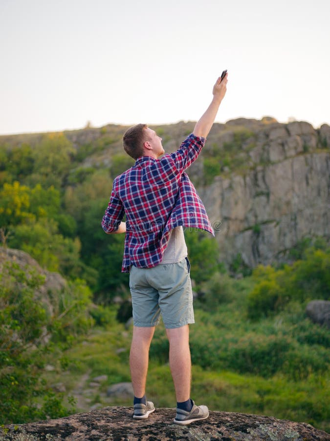 Hombre joven sin Internet en un fondo natural Rocas que suben del viajero para un mejor concepto de la conexión Copie el espacio fotografía de archivo libre de regalías Hombre joven sin Internet en un fondo natural Rocas que suben del viajero para un mejor concepto de la conexión Copie el espacio fotografía de archivo libre de regalías