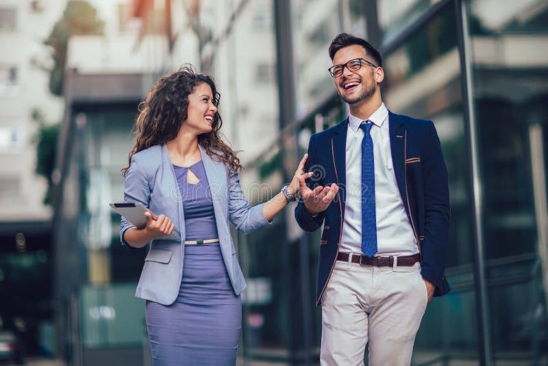 Hombre joven y mujer hermosa como socios comerciales que usan la tableta digital al aire libre foto de archivo libre de regalías Hombre joven y mujer hermosa como socios comerciales que usan la tableta digital al aire libre foto de archivo libre de regalías