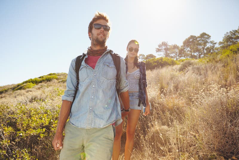 Hombre joven y mujer que caminan en montaña foto de archivo Hombre joven y mujer que caminan en montaña foto de archivo