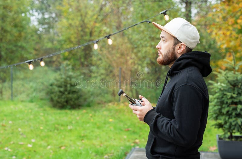 Hombre jugando con drones. Joven jugando con drones al aire libre